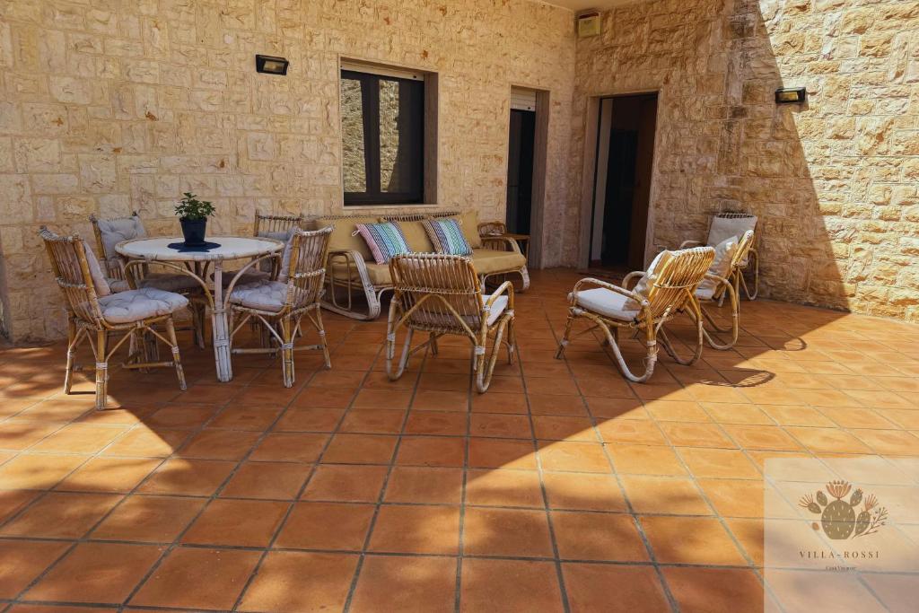 a patio with chairs and a table on a tiled floor at Villa Rossi in Polignano a Mare