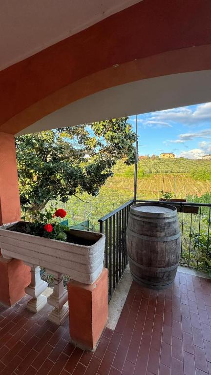 een balkon met een vat, een tafel en bloemen bij Poggio agli Ulivi in Frascati