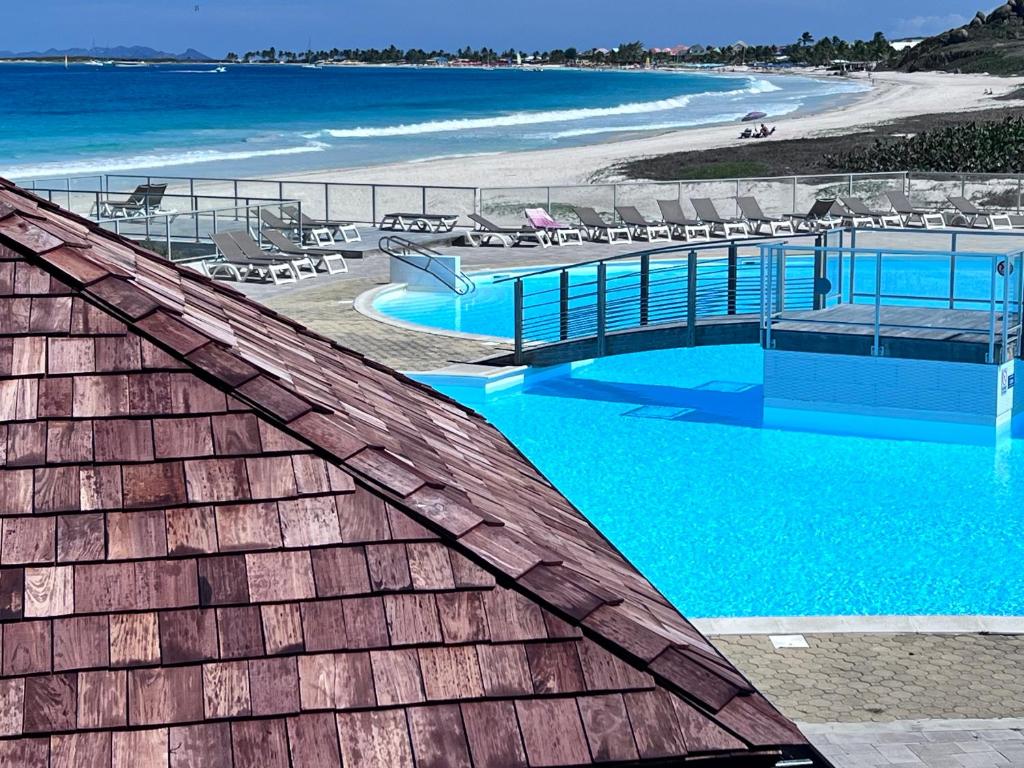 a view of a swimming pool next to a beach at Orient Bay Studio SABA Face à la Mer in Cul de Sac