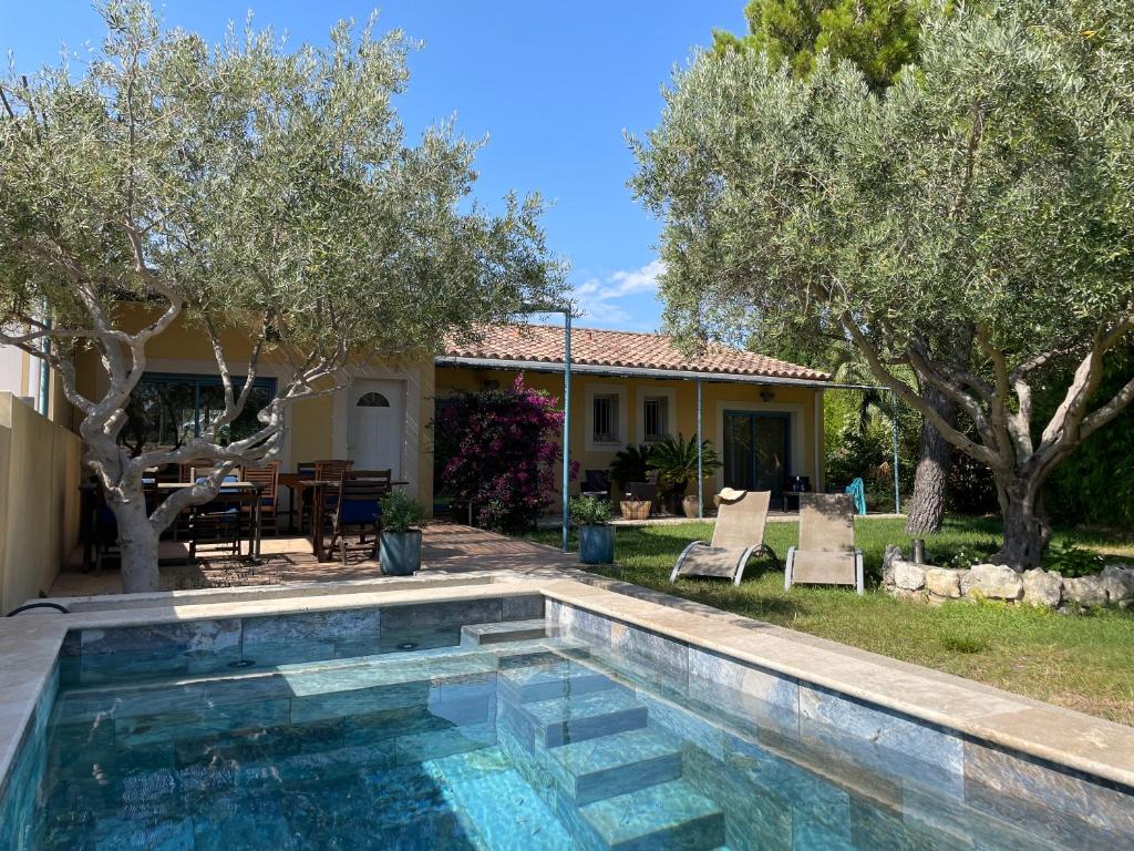 une piscine devant une maison avec des arbres dans l'établissement gite de l'ille, à Peyriac-de-Mer