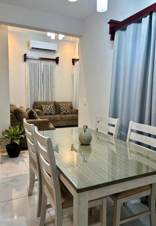 a dining room with a glass table and chairs at Tu hogar en Casa Valencia in San Pedro Sula