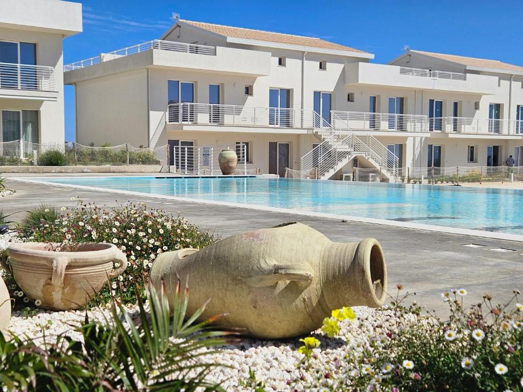 a statue in front of a building with a swimming pool at Bilocale in resort con piscine in Marzamemi