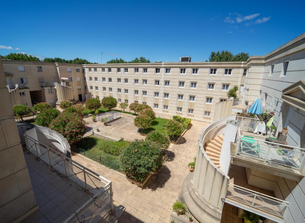une vue aérienne d'un bâtiment avec une cour dans l'établissement T5 Confort & Style - a deux pas de la piscine Olympique, gare et commerces, à Montpellier