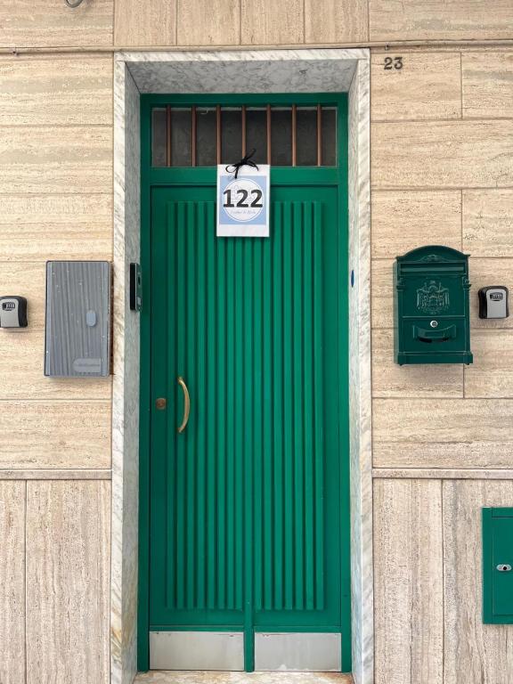 a green door on a building with a sign on it at La Casa di Nonna Sisina in Mola di Bari