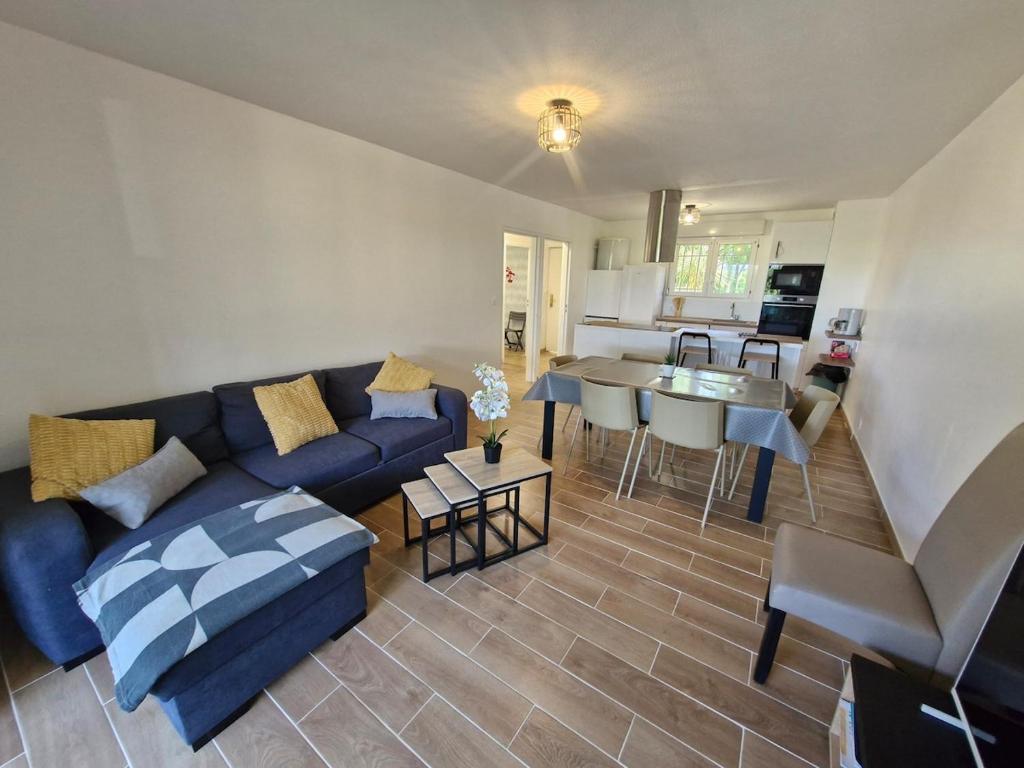 un salon avec un canapé bleu et une cuisine dans l'établissement Le Luna - Fréjus, à Fréjus