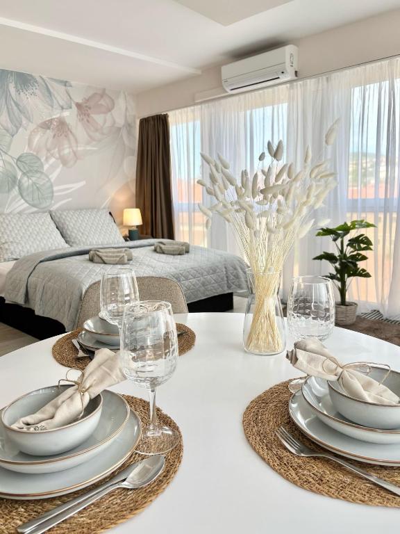 a dining room with a table with plates and wine glasses at HelloWine Apartman III in Eger