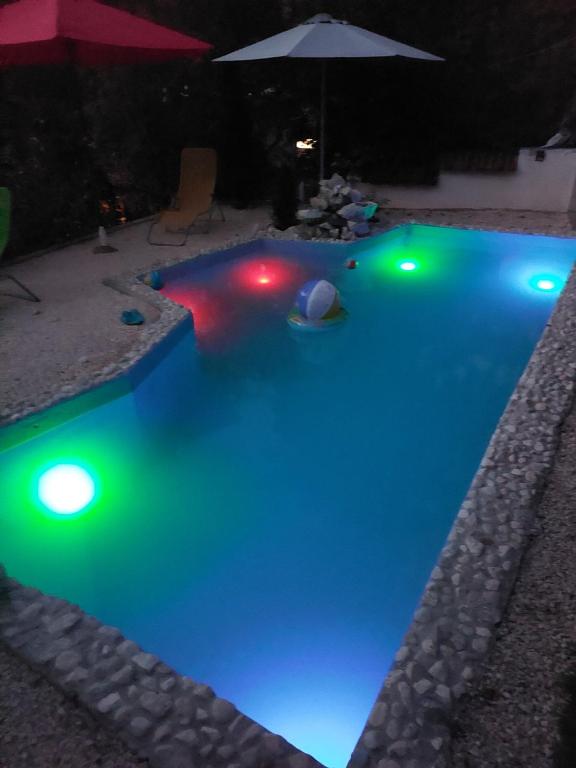 a swimming pool lit up at night with green lights at Apartments Daut's Tower in Sarajevo
