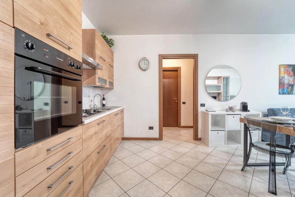 a kitchen with wooden cabinets and a dining room at Residenza Elena in Como