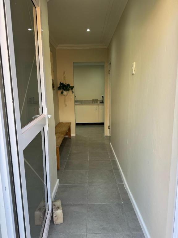 a hallway of a house with a door and a kitchen at Gladys Suites 2 in Gqeberha