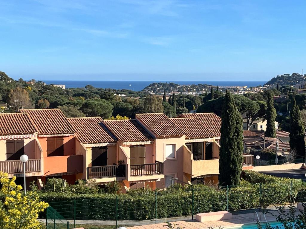 Une rangée de maisons avec l'océan en arrière-plan dans l'établissement Appartement Soleil, à Cavalaire-sur-Mer