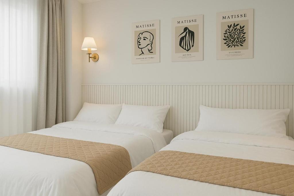 two beds sitting next to each other in a room at Sunny Stay Inn in Seoul