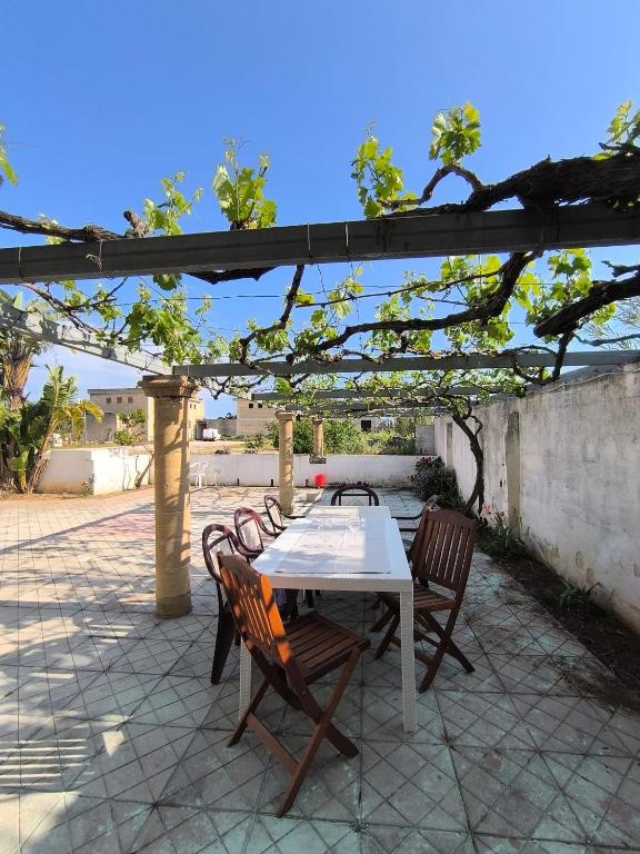 a table and chairs on a patio under a pergola at casavacanza la vite in Alezio