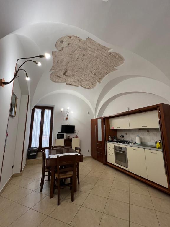 a dining room with a table and a kitchen at il Quadrifoglio in Putignano