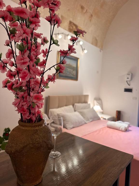 a vase with pink flowers on a table in a living room at Dimora Iryna in Monopoli