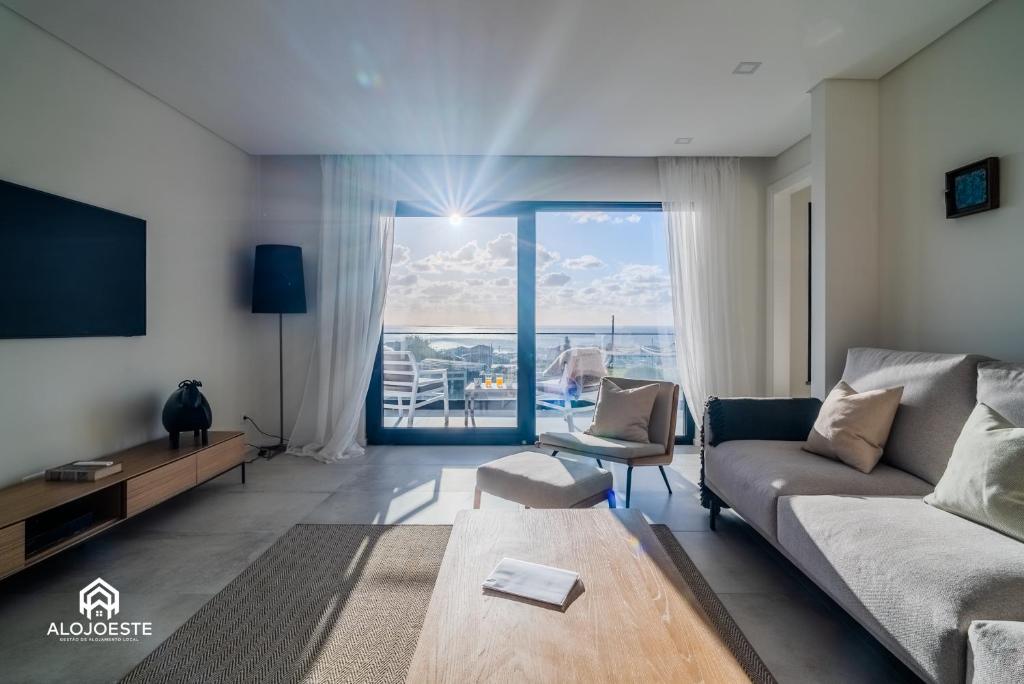 Una sala de estar con un sofá y un televisor. en Can Sony - Quaint Villa by the Ocean with Pool, en Ericeira