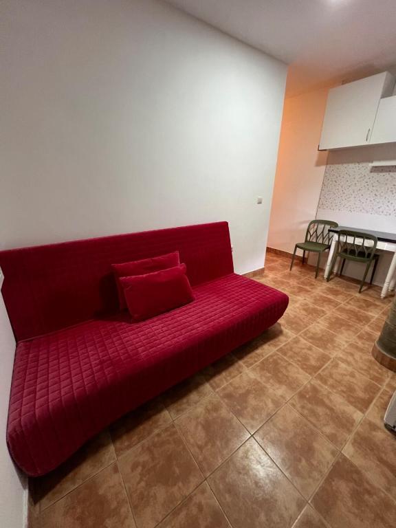 a red couch sitting on the floor in a room at Casa Darío in Ceuta