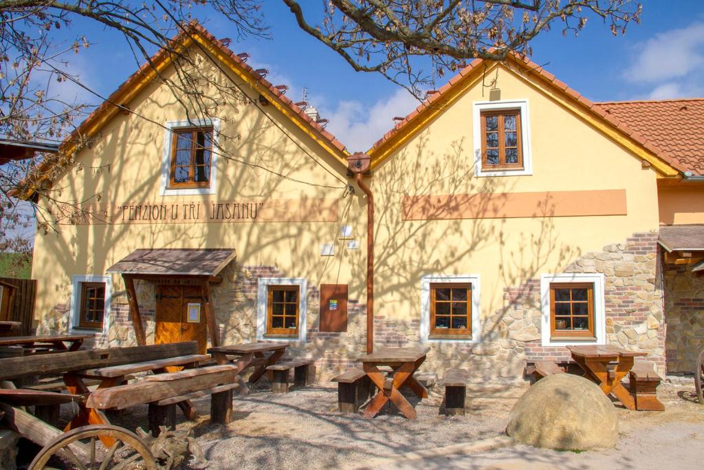 a building with picnic tables in front of it at Penzion U Tří Jasanů in Znojmo