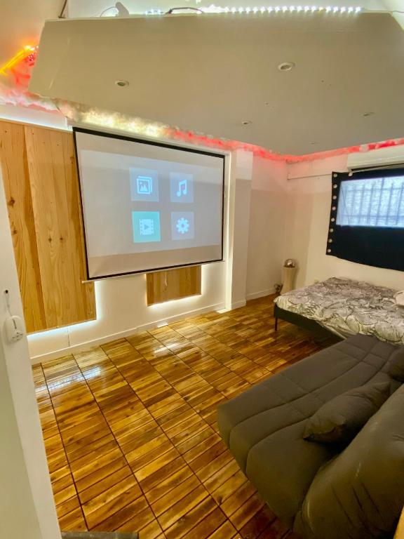 une chambre avec un écran de projection et un canapé dans l'établissement Appartement au cœur de Béziers, à Béziers