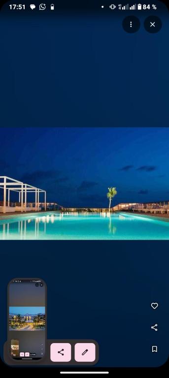 a cell phone sitting next to a picture of a pool at Hôtel Novotel in Kika