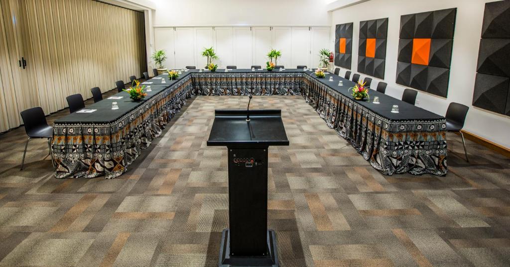 a conference room with long tables and chairs in it at The Pearl South Pacific Resort, Spa & Golf Course in Pacific Harbour
