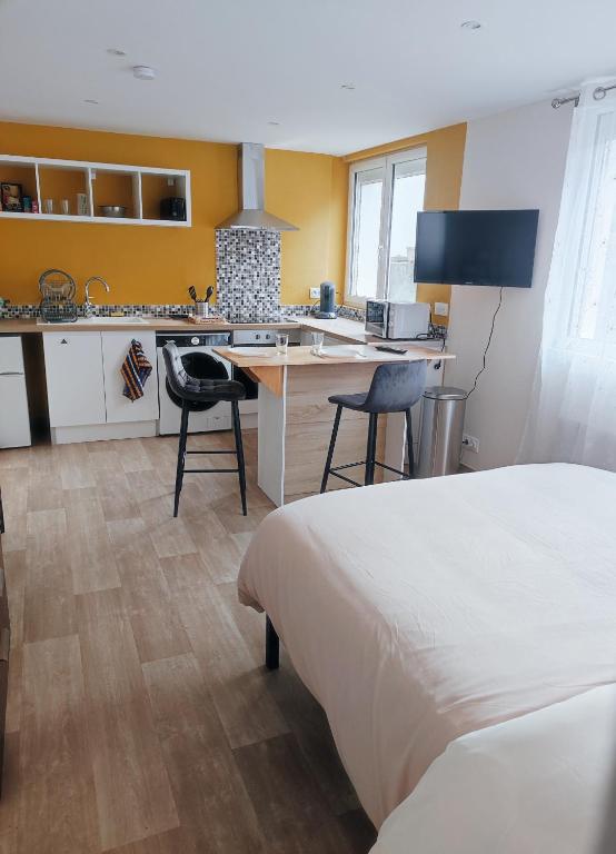 Il comprend une chambre avec un lit et une cuisine avec un bureau. dans l'établissement Studio Carentan, à Carentan