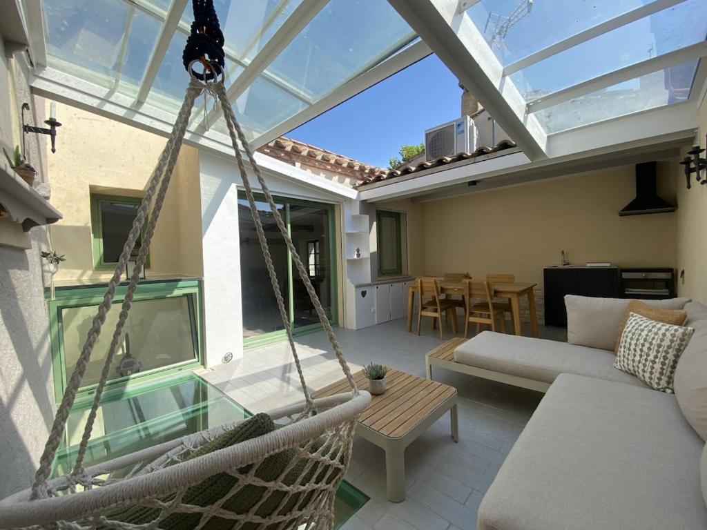 une terrasse couverte avec un hamac et un salon dans l'établissement Maison Gruissan village, à Gruissan