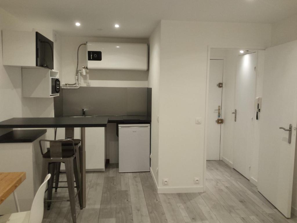 une cuisine avec des armoires blanches et un comptoir dans l'établissement Studio Peyrou Arceaux, à Montpellier