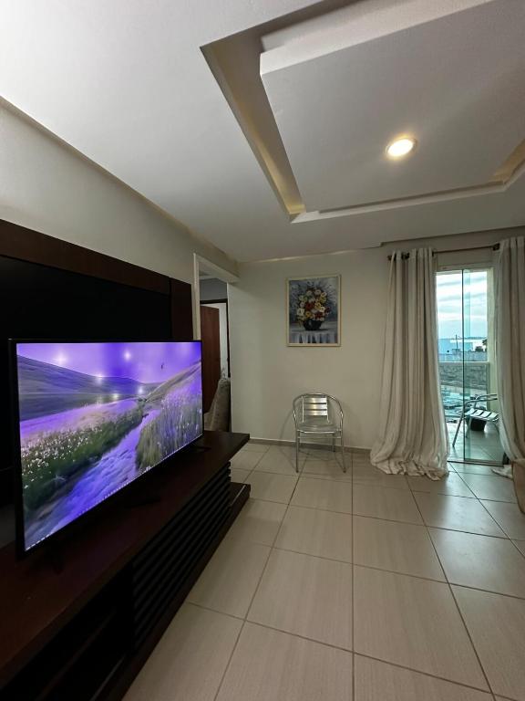 a living room with a large flat screen tv at Apartamendo Marina Clube in São Pedro da Aldeia