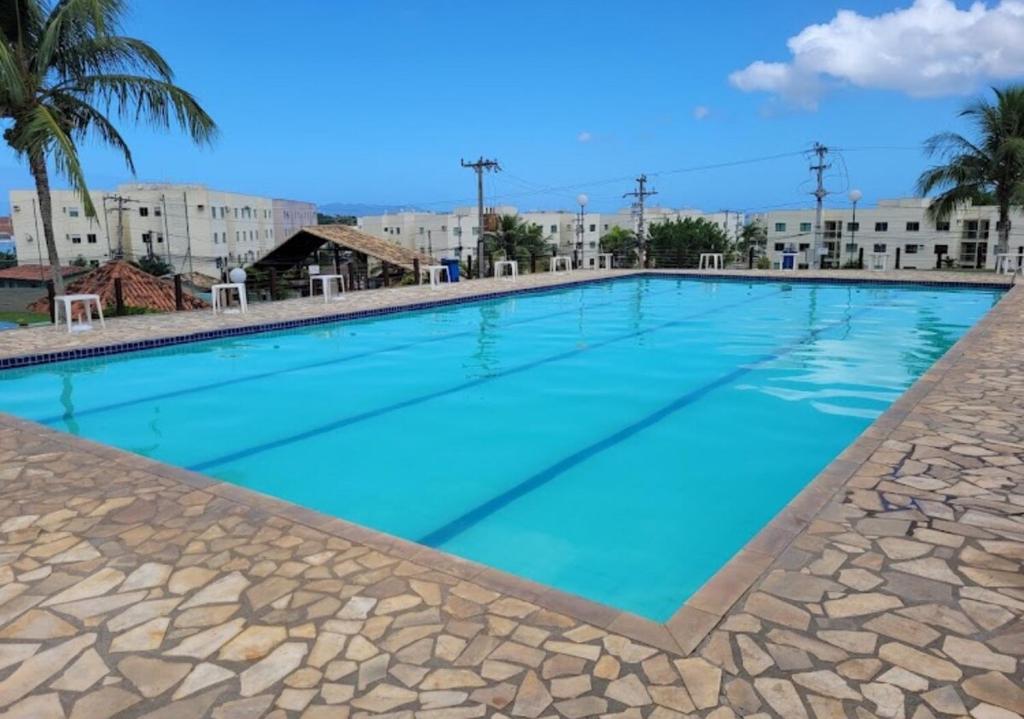 una gran piscina con agua azul en Apartamendo Marina Clube, en São Pedro da Aldeia