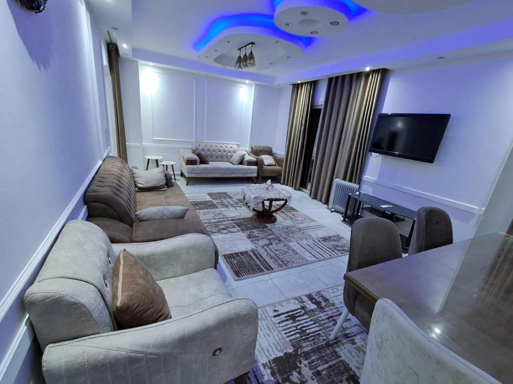 a living room with couches and a flat screen tv at شقة فندقية بالشيخ زايد الخمائل in Kafr Abū ʼumaydah