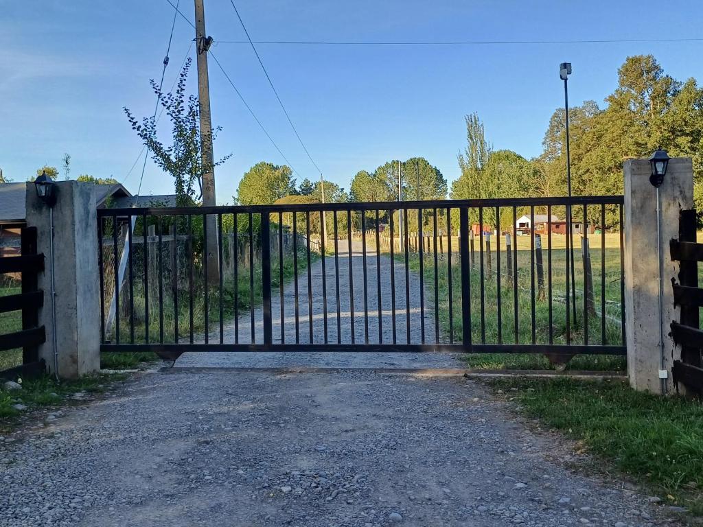 a gate to a pasture with a field behind it at Cordero in Osorno