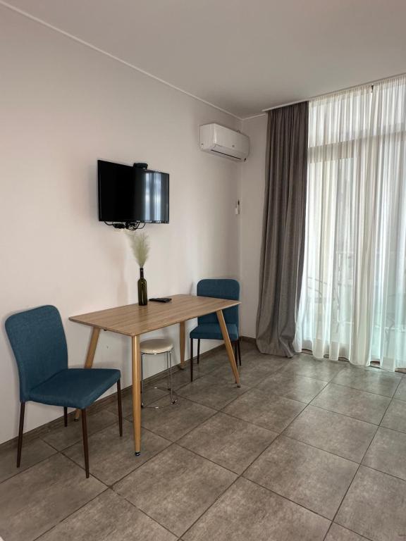 a room with a table and chairs and a television at Aqua Batumi 39 in Batumi