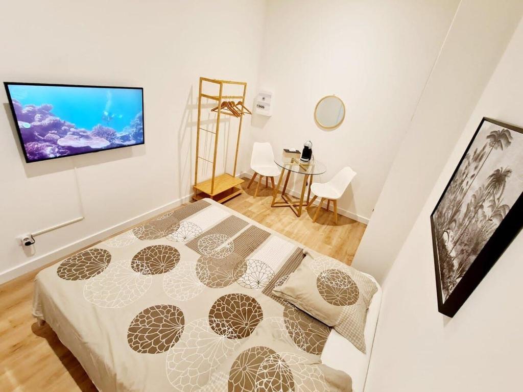 une chambre avec un lit et une télévision sur un mur dans l'établissement Le Marty 2 Studio, à Carcassonne