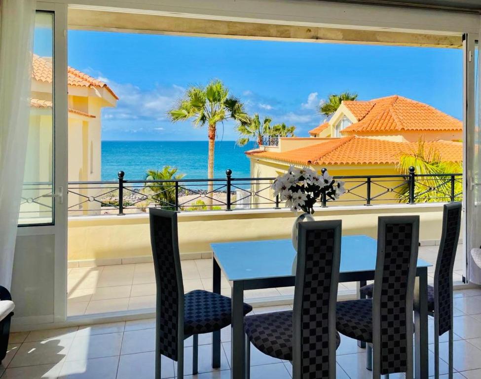 a dining room with a table and a view of the ocean at Villa Sol Los Cristianos in Los Cristianos