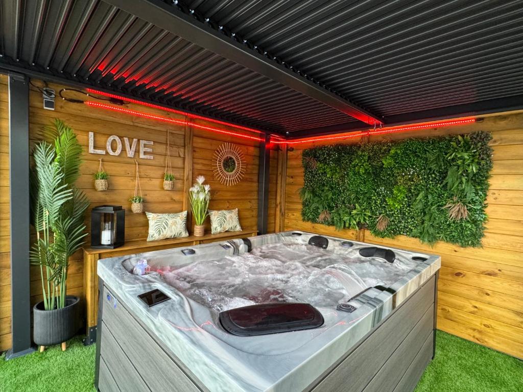 une baignoire jacuzzi au milieu d'un jardin dans l'établissement Logement cosy avec piscine et jacuzzi privé, à Poussan