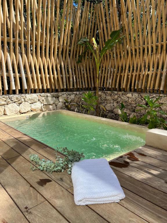 トゥルムにあるMeDaYa Selva Retreatの木製のデッキにタオルが敷かれたプール