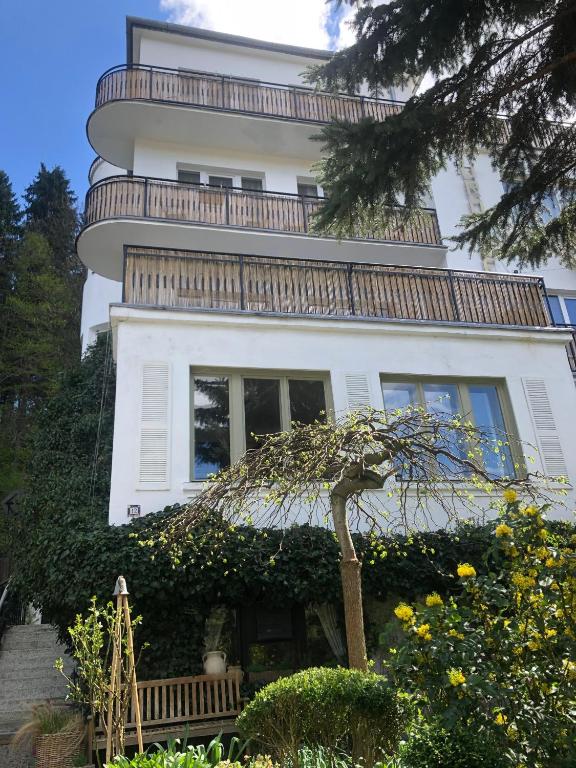 a white house with a tree in front of it at Willa Urocze in Muszyna