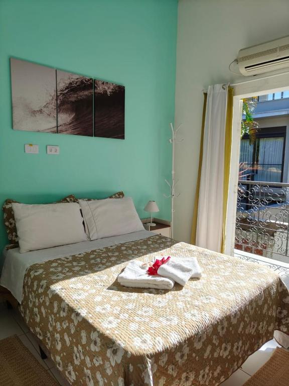 Un dormitorio con una cama con toallas. en Pousada Casa da Praia Juquehy - Duplo, en Juquei