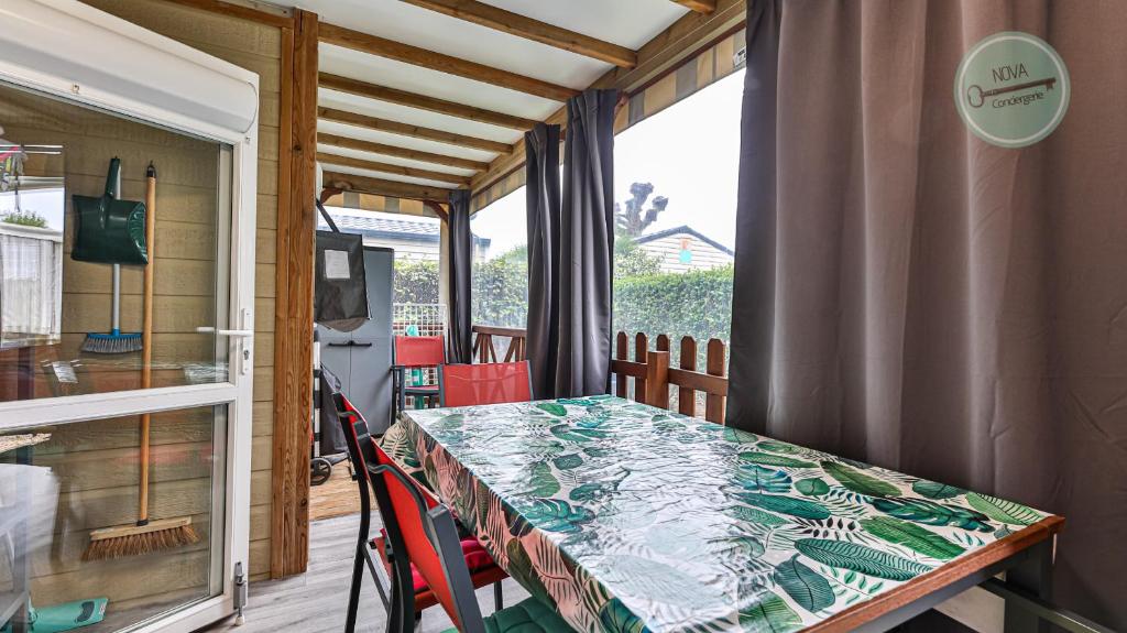 a dining room with a table and a window at Chalet 68 Village de la Mer in Saint-Hilaire-de-Riez