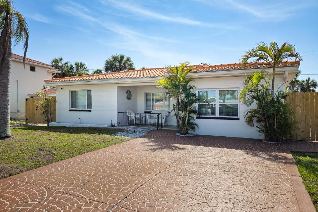 a white house with palm trees in front of it at Paradise Found in Clearwater Beach