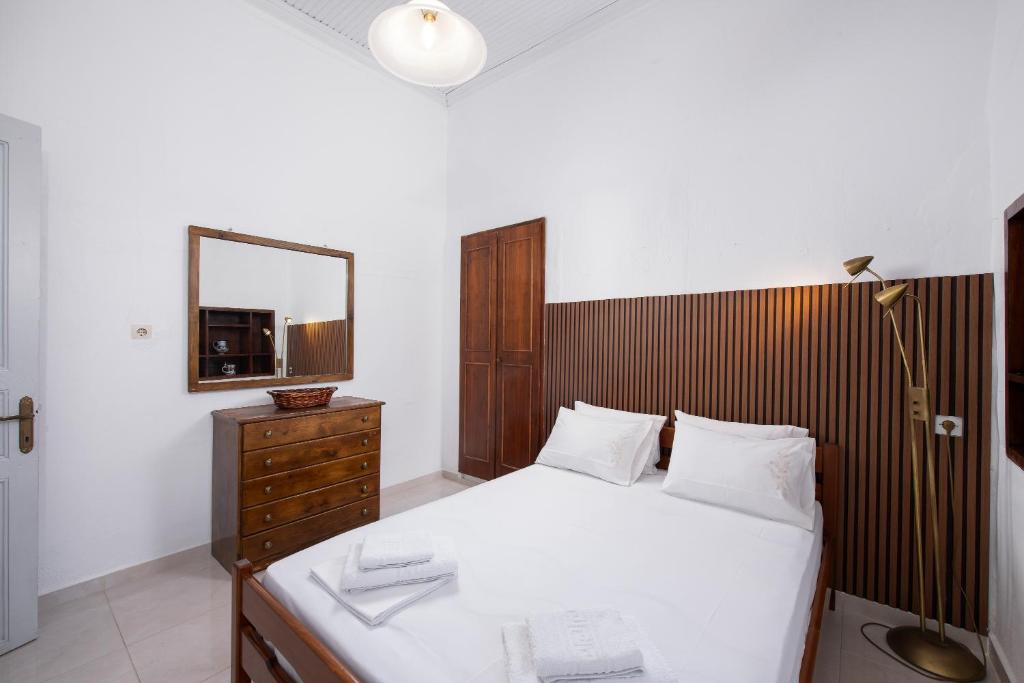 a bedroom with a bed with a mirror and a dresser at Michael&Marika's Traditional House in Limenaria