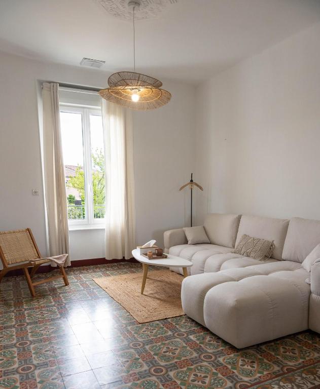 un salon avec un canapé blanc et une table dans l'établissement Villa Léa Alès 5 chambres, à Alès