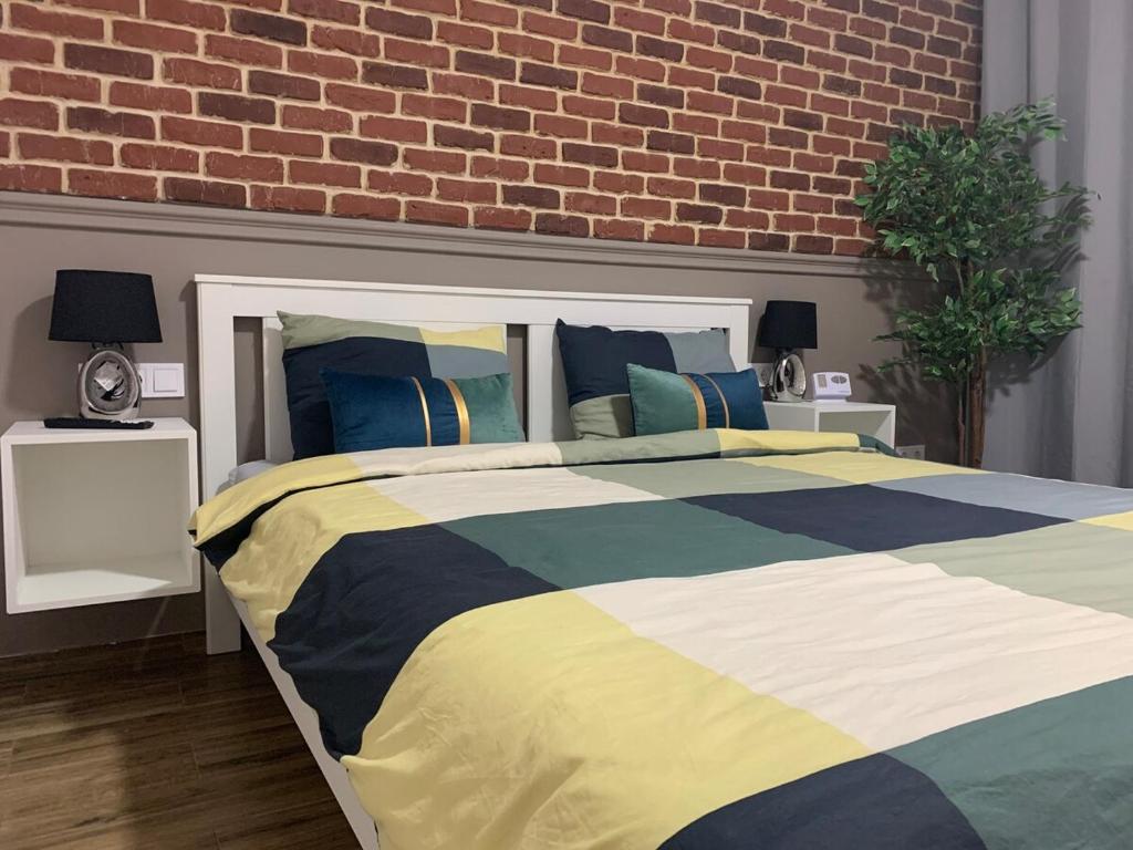 a bedroom with a bed and a brick wall at DBO Kaufland-Vivo in Baia Mare