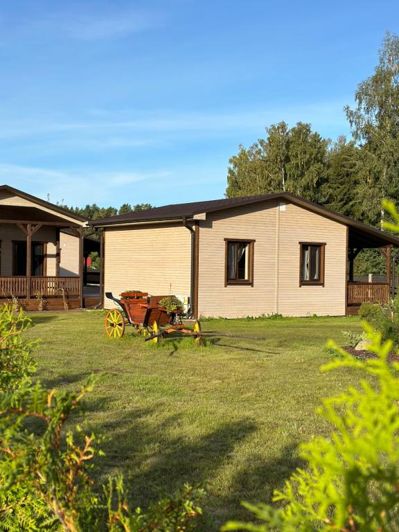 a house with a wagon parked in the yard at Brunella house at Villa Vlada in Gāršmuiža