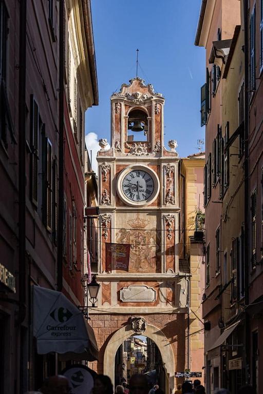 una torre dell'orologio sul lato di un edificio di Loano Experience - 70m dal mare a Loano