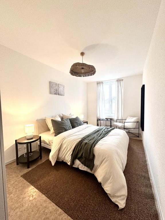 a bedroom with a large bed and a chandelier at L evasion familiale in Mulhouse