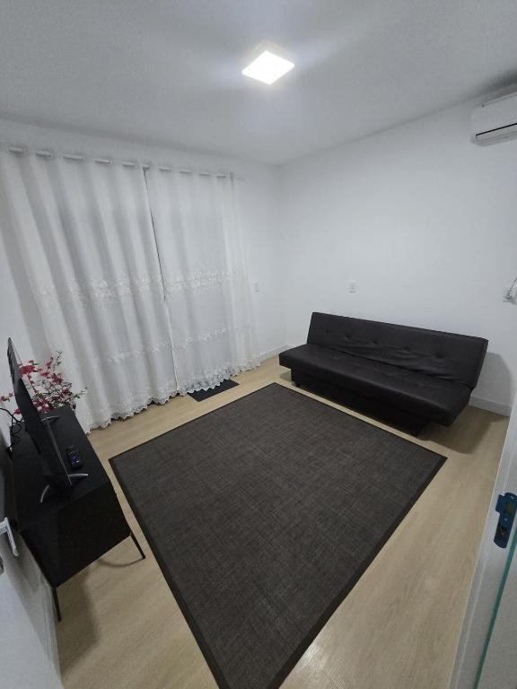 a living room with a couch and a large rug at Aconchego da Família de Oliveira in Camboriú