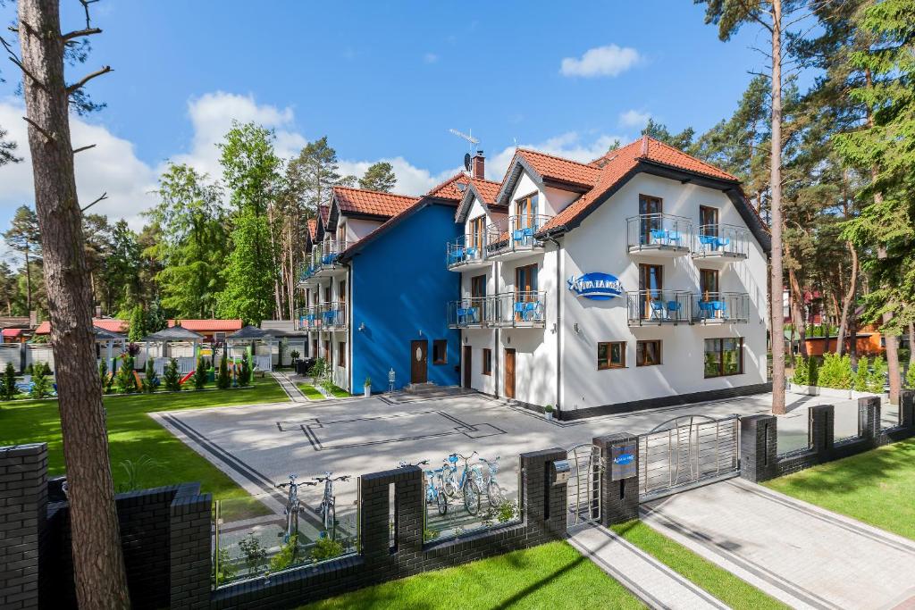 a white and blue building with a yard at VivaLaMer in Pobierowo