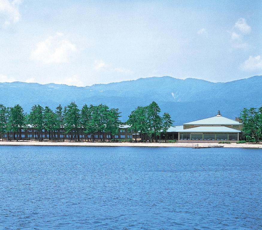 a building on the shore of a body of water at Grand Park Hotel Okubiwako Makino in Takashima