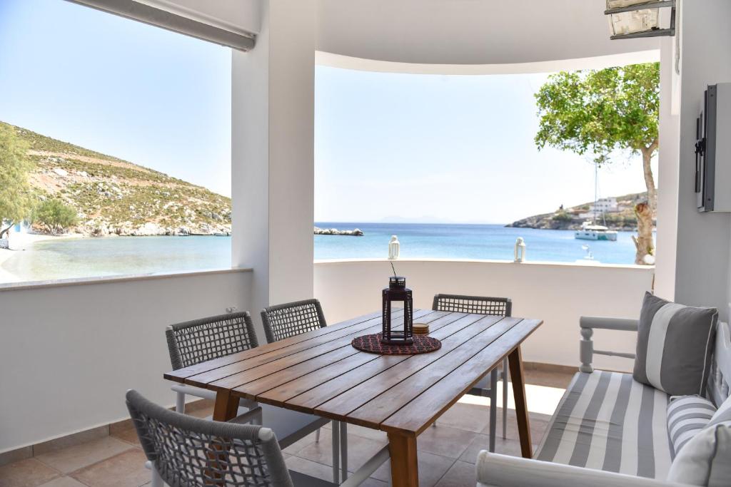 a dining room with a table and chairs and the beach at Faros Anaplioti in Kalymnos